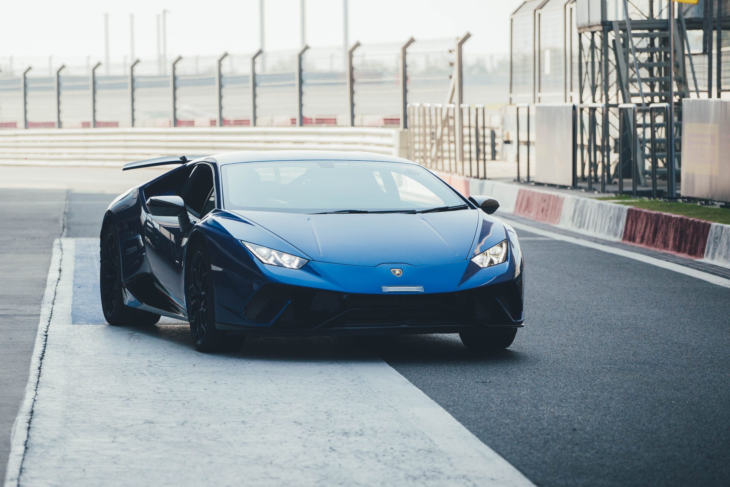 Sleek blue Lamborghini Huracan on a professional racing track in Noida, India.